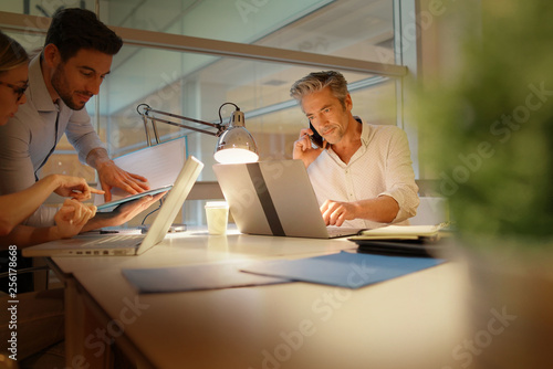 Colleauges working overtime in modern office photo