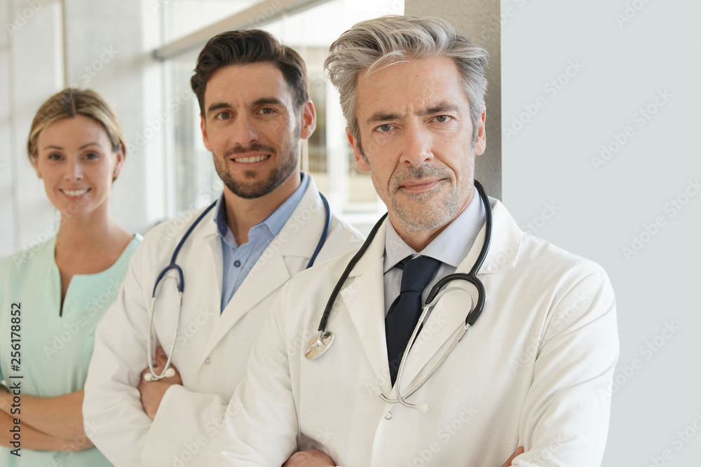 Team of doctors and nurse in hospital looking at camera Team of doctors and nurse in hospital looking at camera