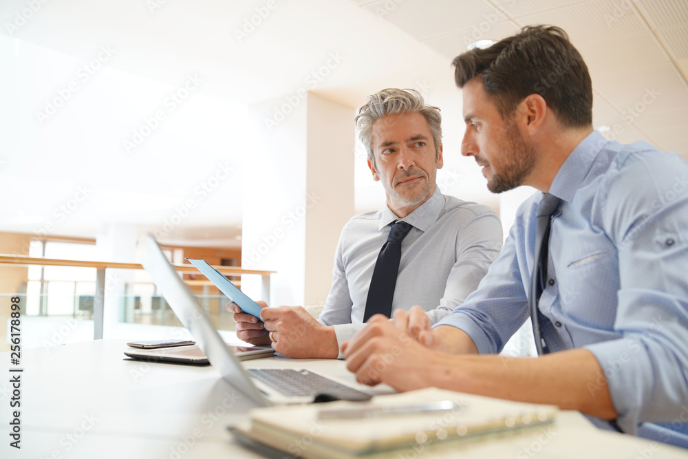 Male coworkers discussing business strategies Male coworkers discussing business strategies