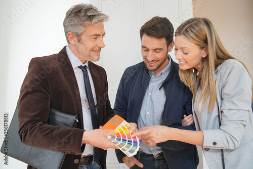 Real estate agent showing couple colour chart in contemporary home photo
