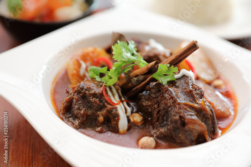 Beef massaman curry with rice and salad on wooden background , Thai food