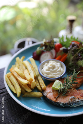 Roasted salmon steak , baked salmon with salad fresh vegetable pm wooden table