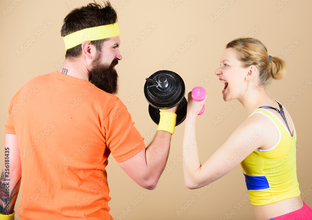 Strong muscles and power. Sport dumbbell equipment. Sporty couple training in gym. Athletic competition. Weight lifting. Happy woman and man workout with barbell. Championships are won at practice Strong muscles and power. Sport dumbbell equipment. Sporty couple training in gym. Athletic competition. Weight lifting. Happy woman and man workout with barbell. Championships are won at practice