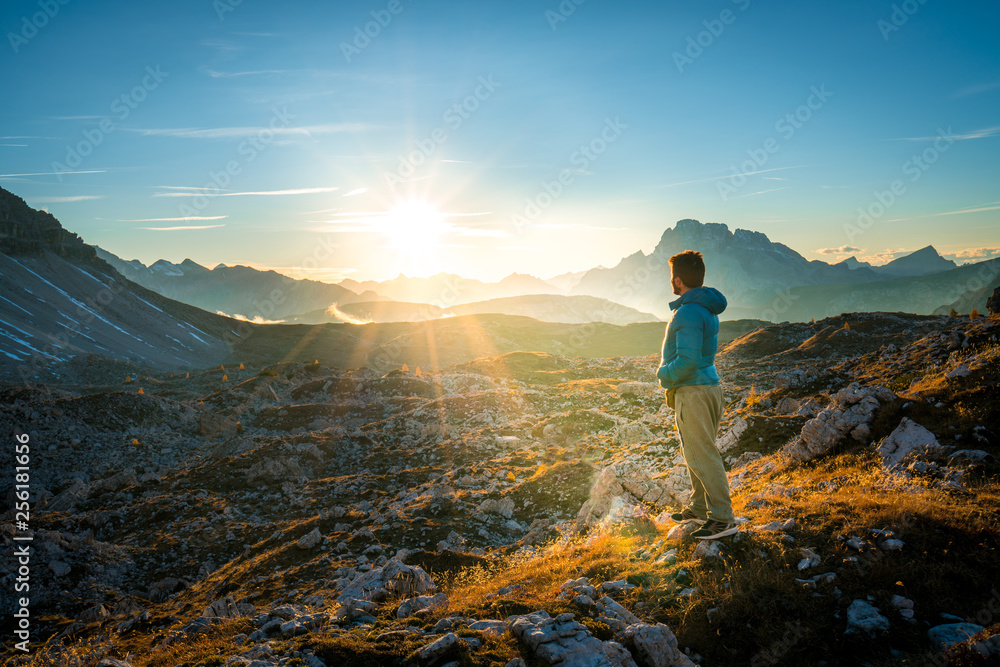 young man enjoying the view of the mountains landscape in the dolomites mountain range. tre cime di lavaredo national park, south tyrol