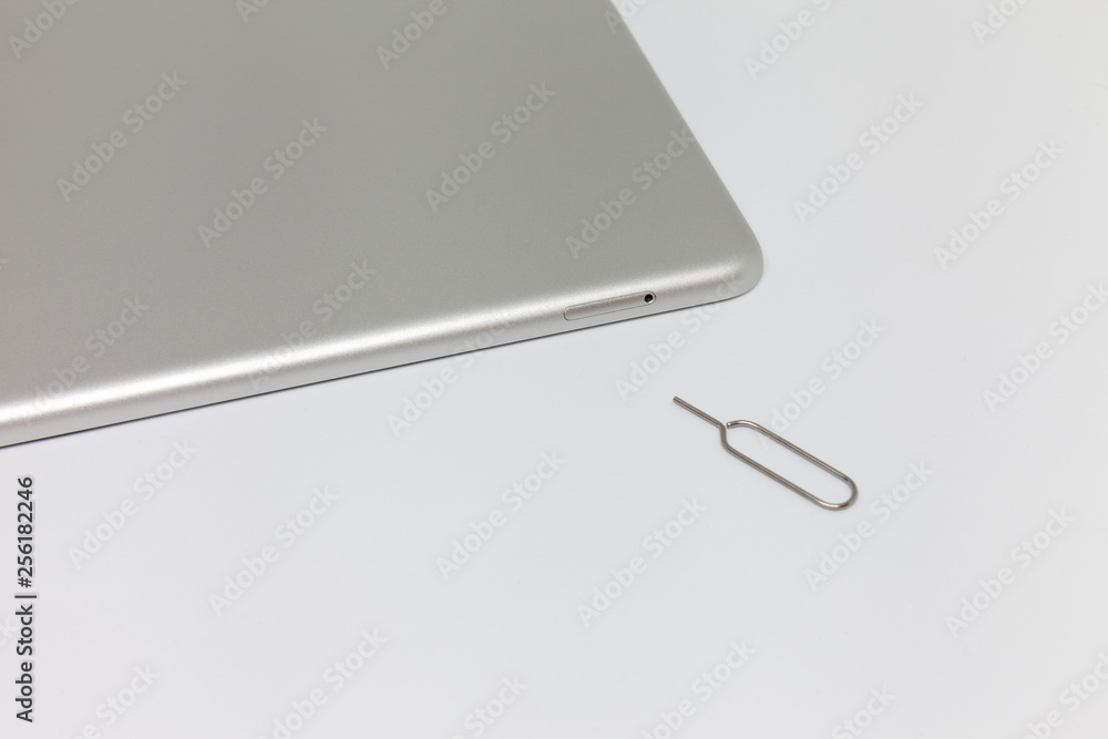 Silver inverted tablet. Visible tray for the SIM card and the key to open Silver inverted tablet. Visible tray for the SIM card and the key to open