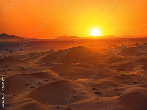 Red sand mountains and sun in sahara desert