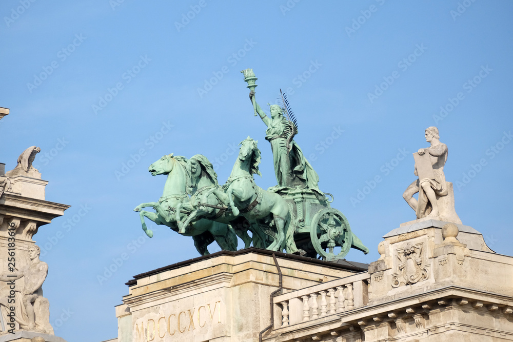 Obraz premium Statues on roof of Museum of Ethnography in Budapest, Hungary. The building located at Kossuth Square, across from the Hungarian Parliament