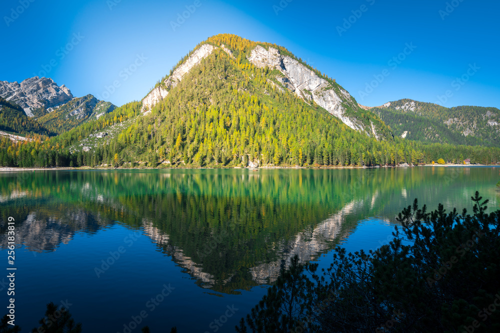 amazing view of braies lake with mountains and forest reflections on the water. northern italy