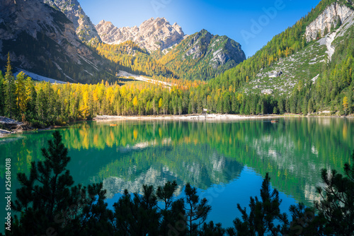 amazing view of braies lake with wooden boats on the water, surrounded by dolomites mountains. Trentino alto adige, Italy