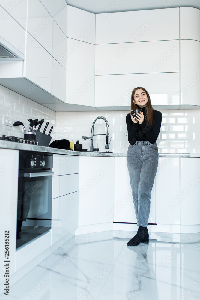 Young woman drinking tea in kitchen in the morning Young woman drinking tea in kitchen in the morning