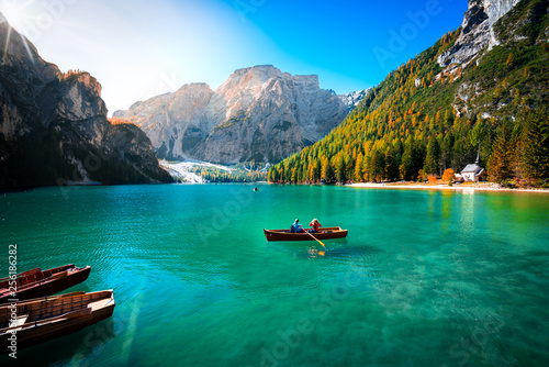 amazing view of braies lake with wooden boats on the water, surrounded by dolomites mountains. Trentino alto adige, Italy
