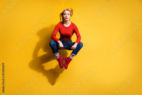Full length body size view of her she nice-looking trendy attractive lovely winsome fashionable sad girl sitting in air isolated over bright vivid shine orange background