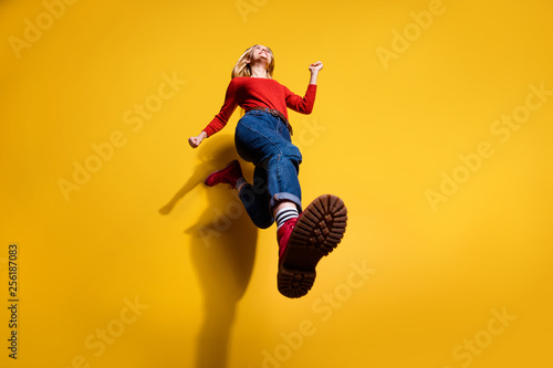 Low below angle full length body size view of nice attractive cheerful girl having fun going making step wearing vintage retro maroon boots isolated over bright vivid shine orange background
