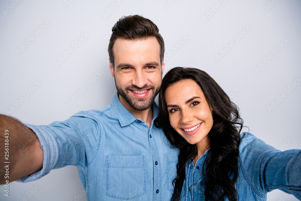 Close up photo of cute sweethearts married spouses making photos memories wearing blue denim clothes isolated over grey background Close up photo of cute sweethearts married spouses making photos memories wearing blue denim clothes isolated over grey background