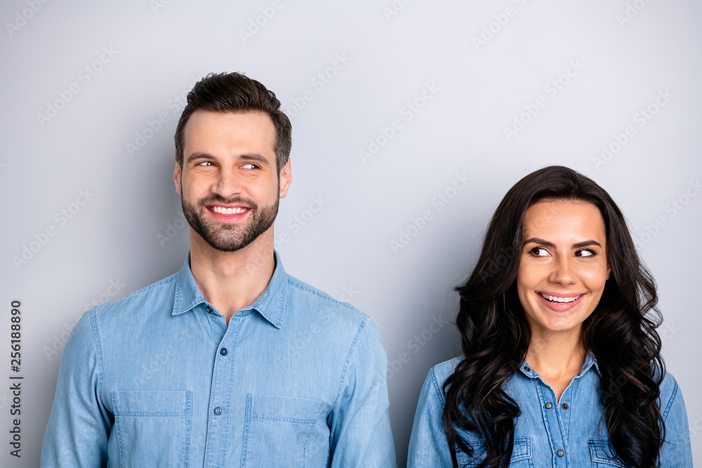Portrait of two affectionate pretty modest students workers meeting feeling carefree positive isolated dressed in blue denim outfit on silver background