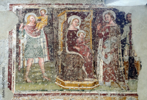 Enthroned Madonna and Child, Saints Christopher, Catherine, George and a worshipper Knight, fresco in the church of San Pietro Martire in Verona, Italy © zatletic