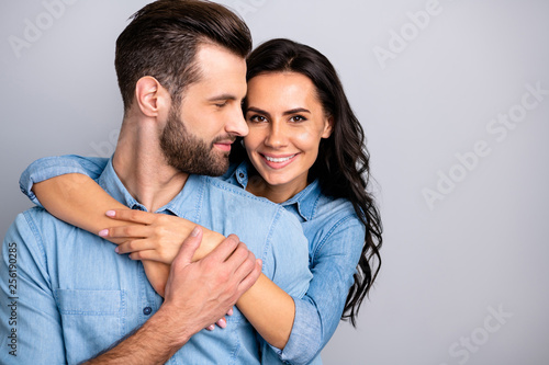 Love affair. Portrait of charming couple of millennial cheerful positive placing hands around chest wavy curly hair wearing blue denim shirts isolated on grey background 