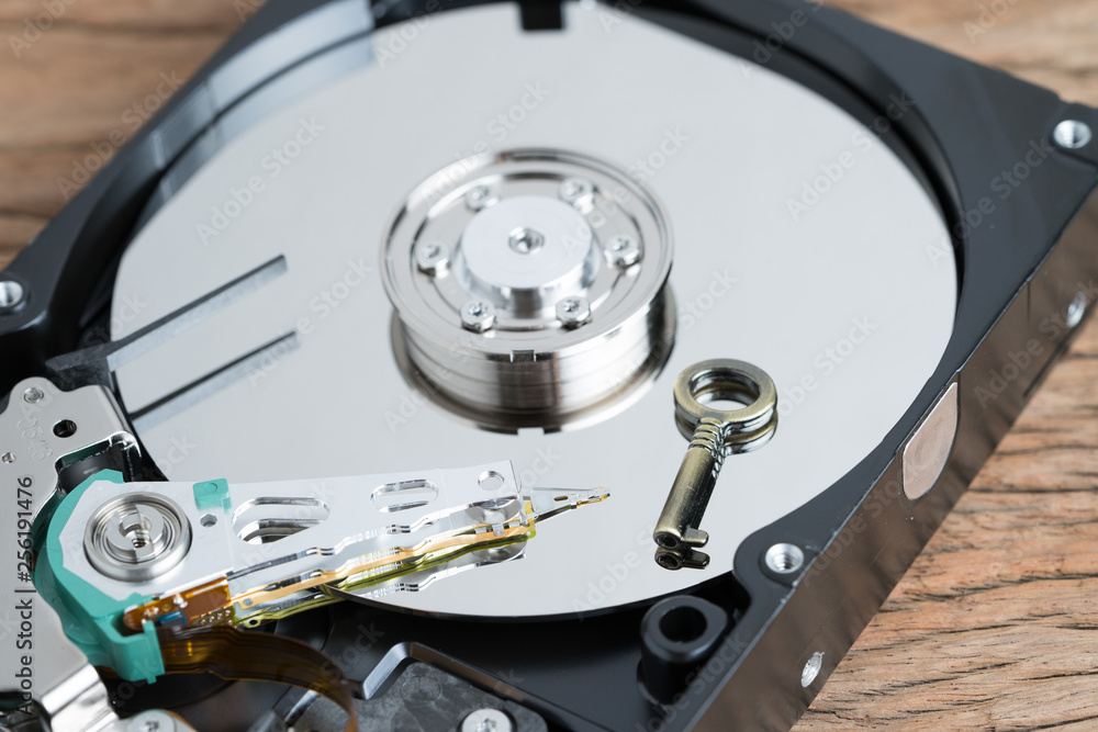 Small bronze metal key on hdd, hard drive using as privacy and data security, encoding or encryption concept Small bronze metal key on hdd, hard drive using as privacy and data security, encoding or encryption concept