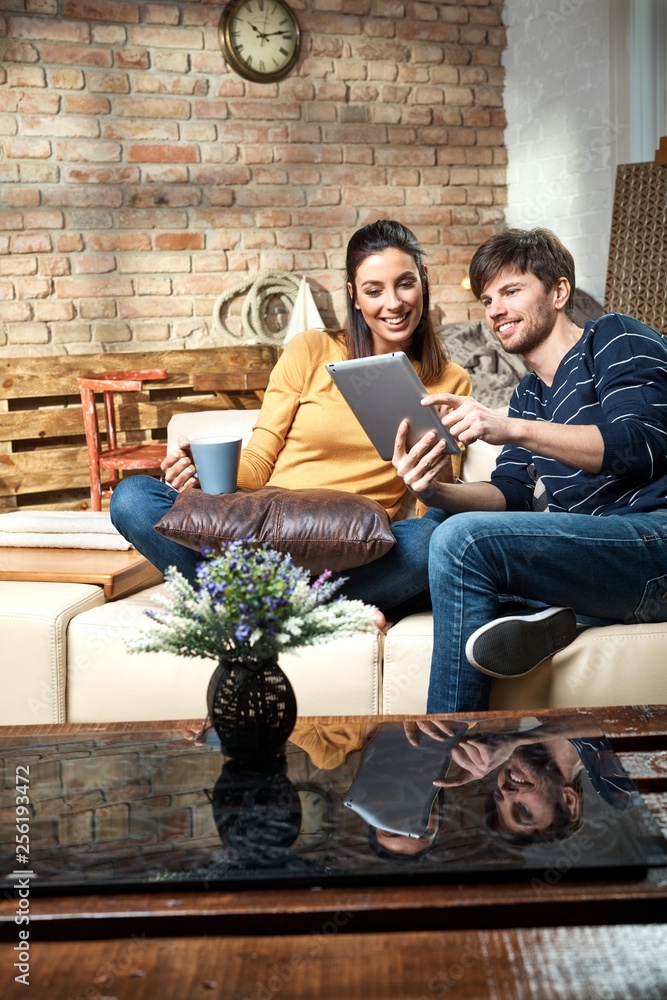 Obraz premium Happy couple using tablet at home