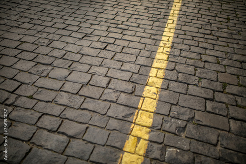 Yellow line on paving stone as abstract background