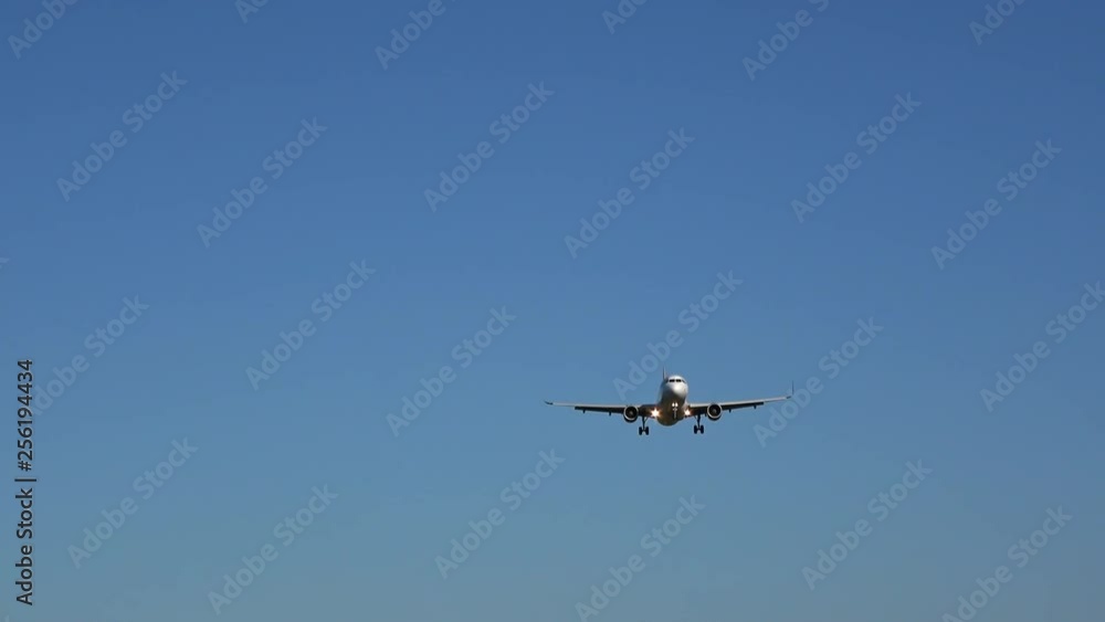 4K. Commercial passenger plane losing height in the blue sky, preparing to land at the airport. There are no clouds in the sky. 4K. Commercial passenger plane losing height in the blue sky, preparing to land at the airport. There are no clouds in the sky.