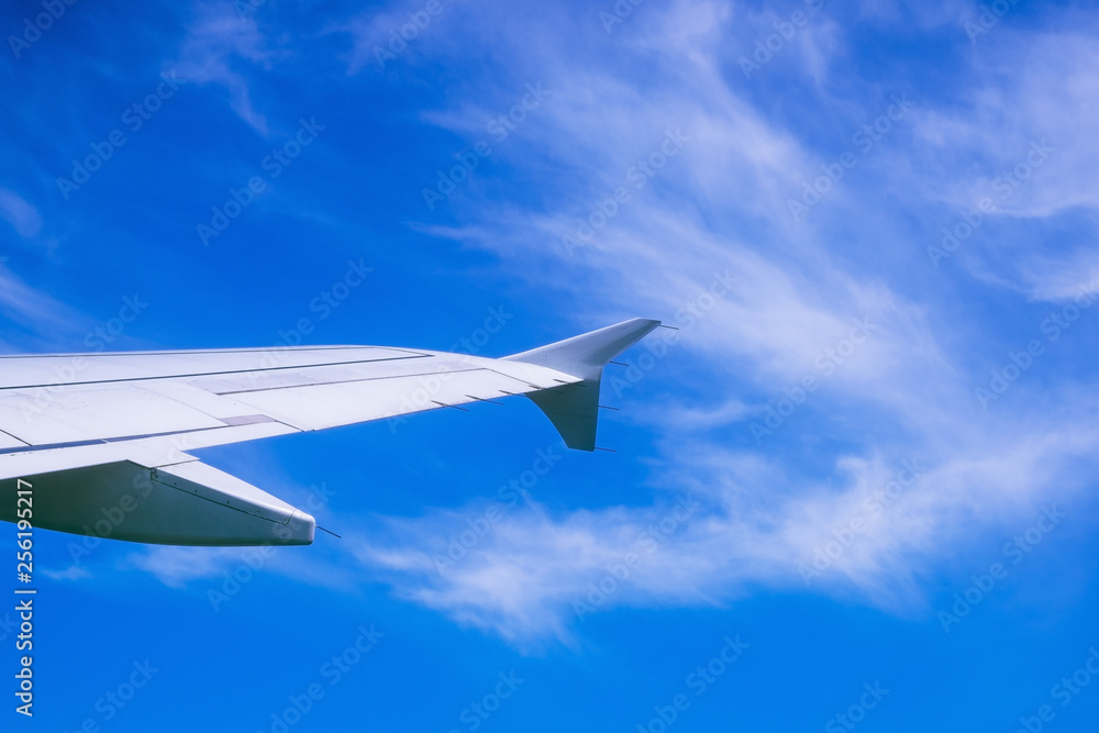 Wing of airplane flying above the clouds in the sky Wing of airplane flying above the clouds in the sky