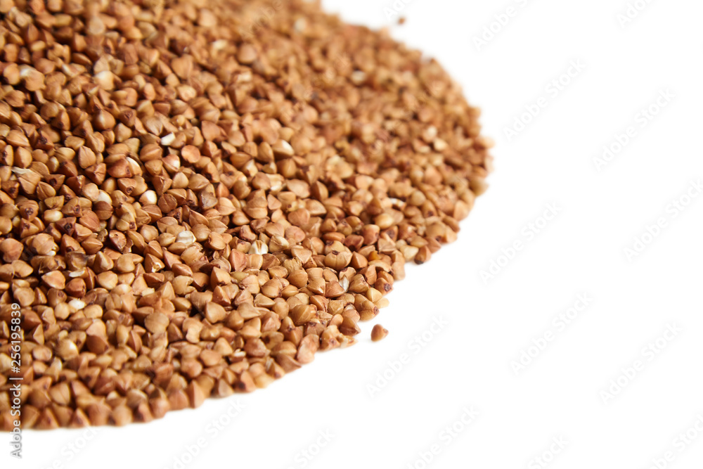Heap of buckwheat grains. Dry brown kernel on white background. Selective focus Heap of buckwheat grains. Dry brown kernel on white background. Selective focus