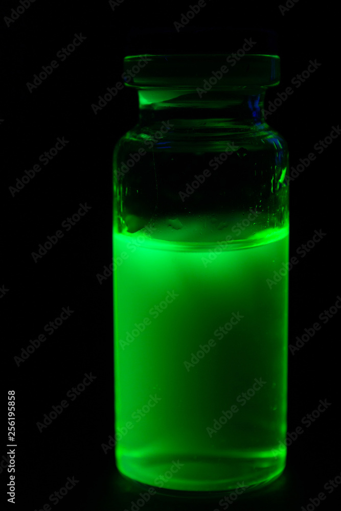Vial yellow fluorescent paint in the UV-blacklight Vial yellow fluorescent paint in the UV-blacklight