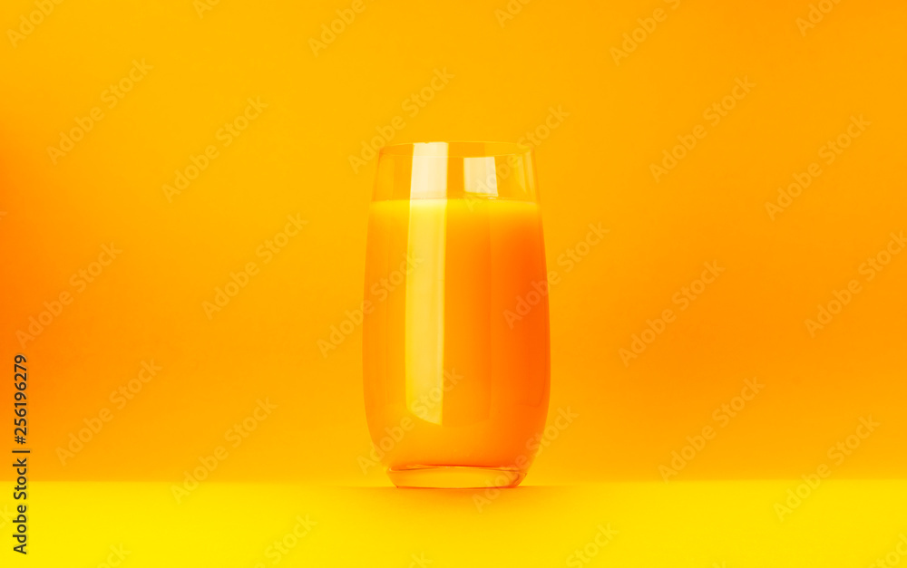 Glass of orange juice isolated on yellow background with copy space Glass of orange juice isolated on yellow background with copy space