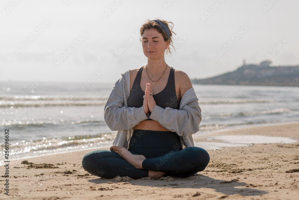 chica meditando en la orilla del mar 