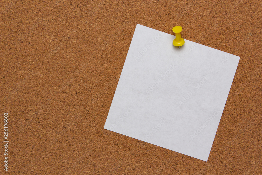 White note sheet pinned on cork board White note sheet pinned on cork board