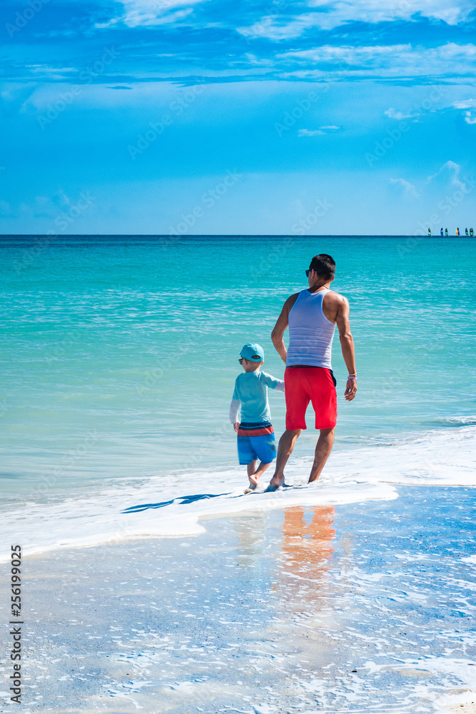 Padre e hijo disfrutando en una playa tropical Stock Photo | Adobe Stock