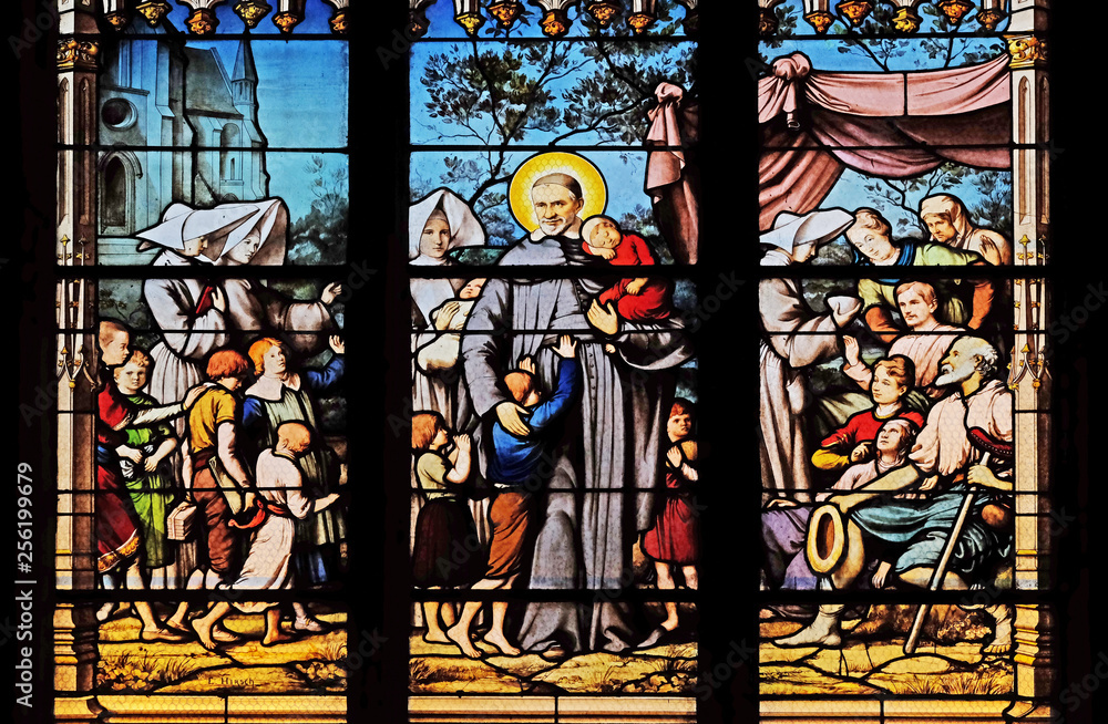 Saint Vincent de Paul gathering with the Daughters of Charity abandoned children, stained glass window in Saint Severin church in Paris, France