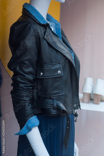 closeup of black leather jacket on mannequin in fashion store showroom for women photo