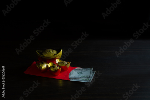 China piece gold and Red envelope money or gratuity in new year chinese called *Angpao* on brown wooden table background