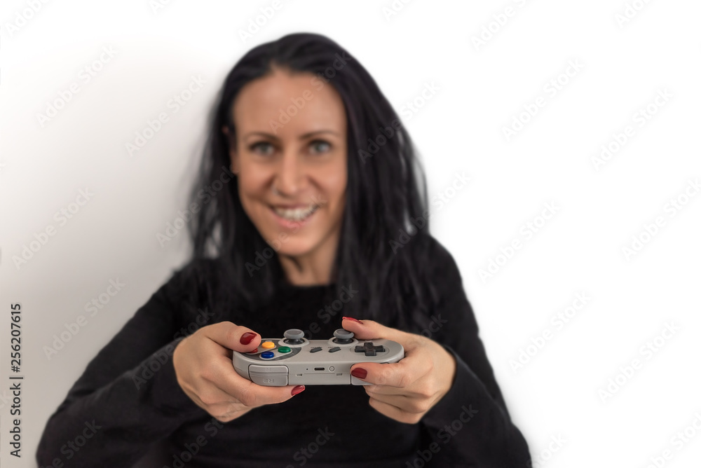 Young woman with red nail polish playing video game on a retro wireless gaming controller with a happy and concentrated facial expressions isolated on white background Young woman with red nail polish playing video game on a retro wireless gaming controller with a happy and concentrated facial expressions isolated on white background