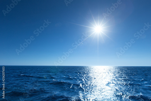 Canvas Print blue sky over calm sea with sunlight reflection