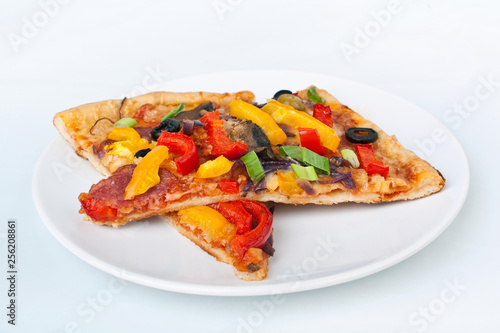 Two slices of vegetable, pepperoni and mushroom pizza on white background
