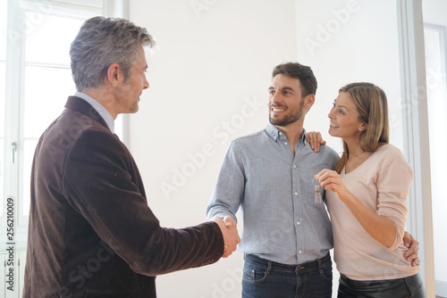 Estate agent handing over keys to happy new home owners