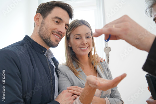 Tableau sur toile Estate agent handing over keys to happy new home owners