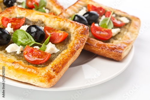 Mediterranean puff pastry with pesto, cherry tomatoes, olives and feta cheese 
