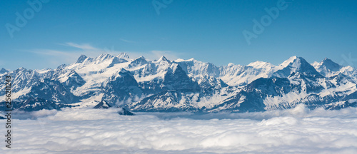 Switzerland, scenic panoramic view on snow Alps peaks above white clouds © AlehAlisevich