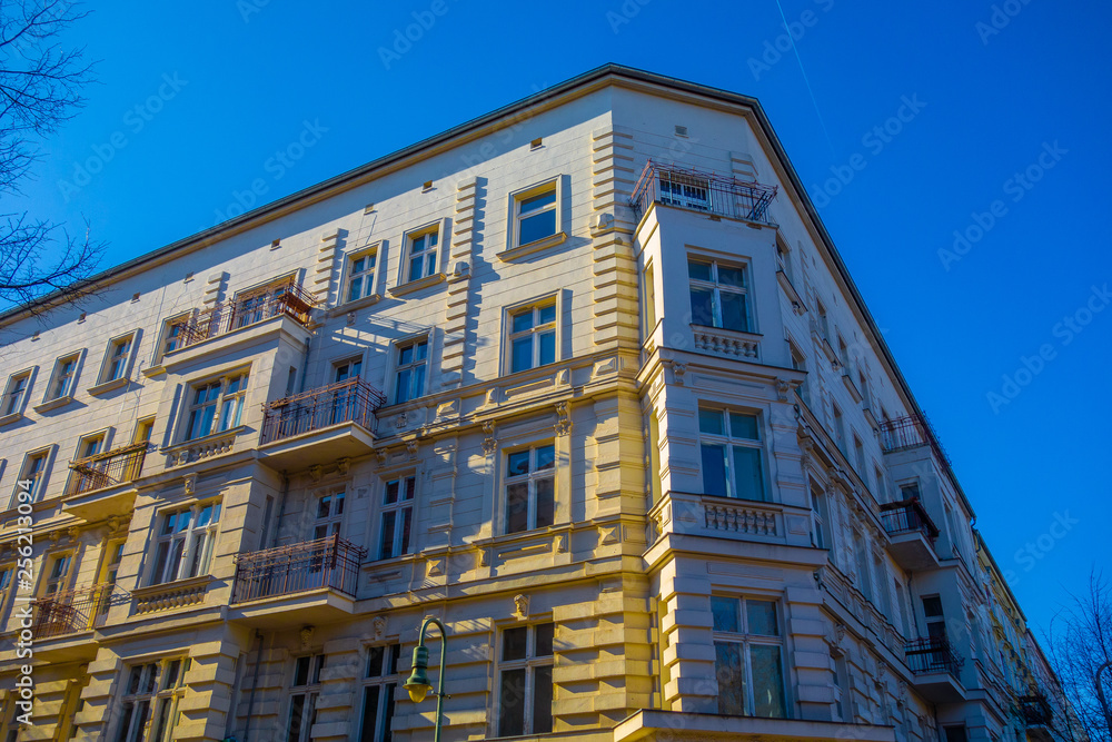 yellow corner building with small balcony from the low angle view with deep blue sky yellow corner building with small balcony from the low angle view with deep blue sky
