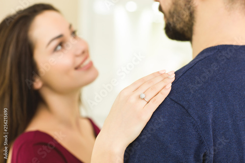 Happy young loving couple choosing an engagement ring at the jewelry store