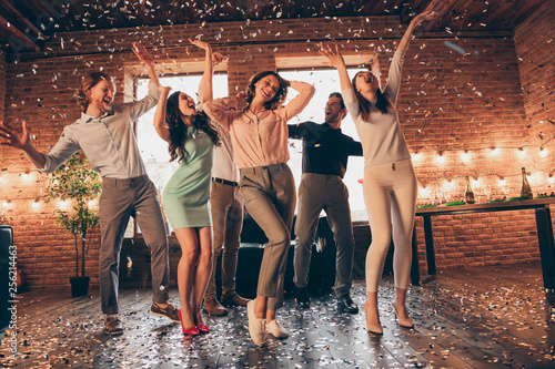 Full length body size view of nice company pretty charming attractive cheerful glad positive guys ladies having fun disco flying decorative elements rejoicing in industrial loft interior house