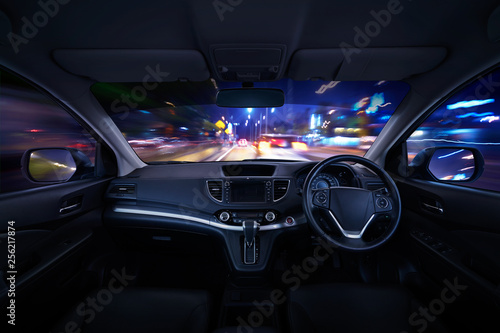 Modern black car dashboard interior with moving motion blur street background, luxury car interior concept . © jamesteohart