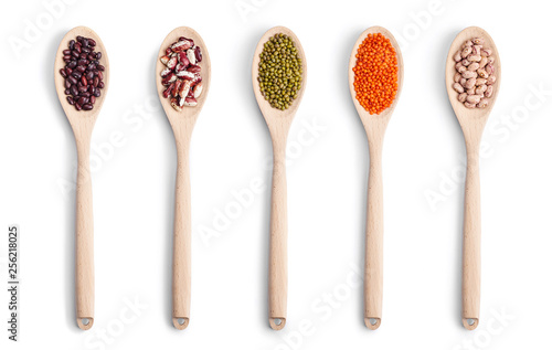 A set of wooden spoons with different beans isolated in white background. Top view.