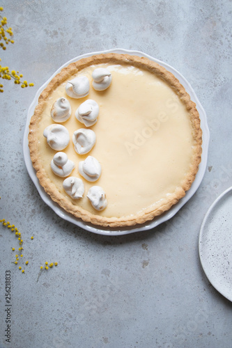 Traditional lemon tart with curd filling decorated with meringues.