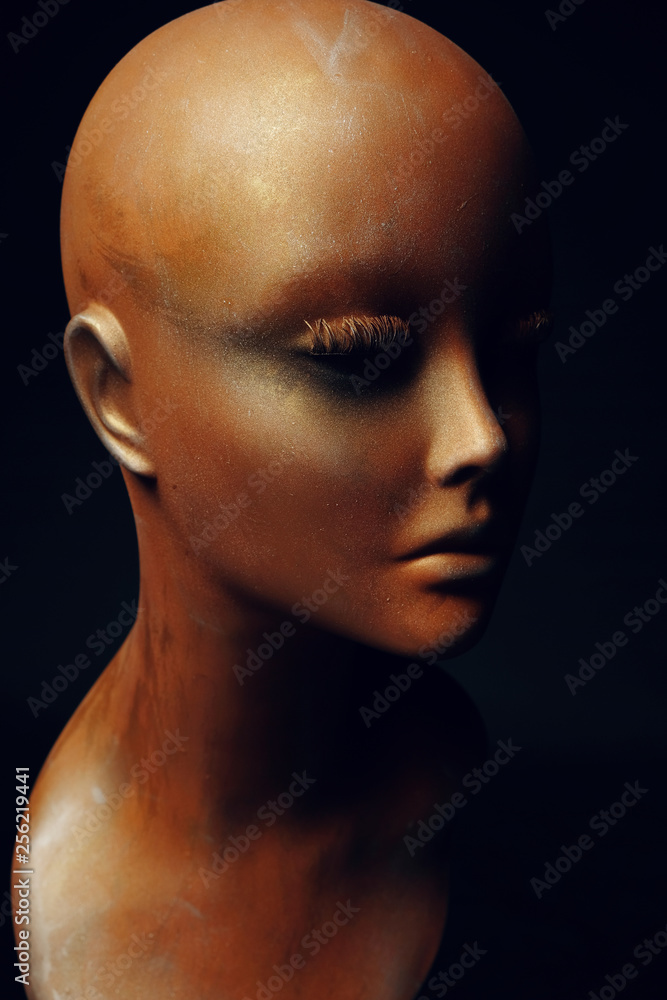 Closeup studio shot of colored woman mannequin with stylish decoration, dark background