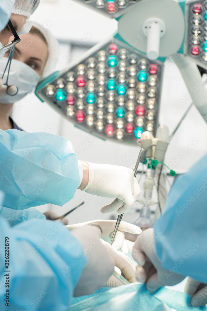 Team of surgeons performing surgery in operation room Team of surgeons performing surgery in operation room